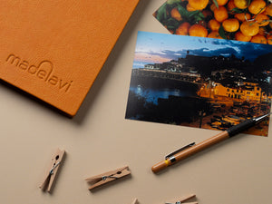 Yellow Leather Photo Album with printed photographs next to it.