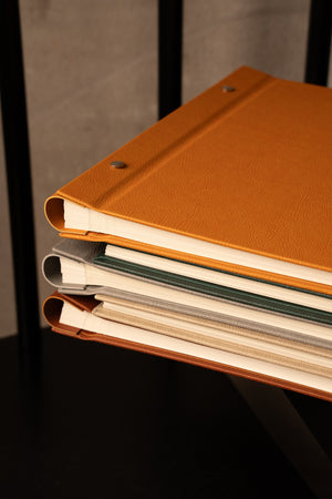 Madelavi photo albums placed horizontally, showcasing the album's thickness in clear detail.